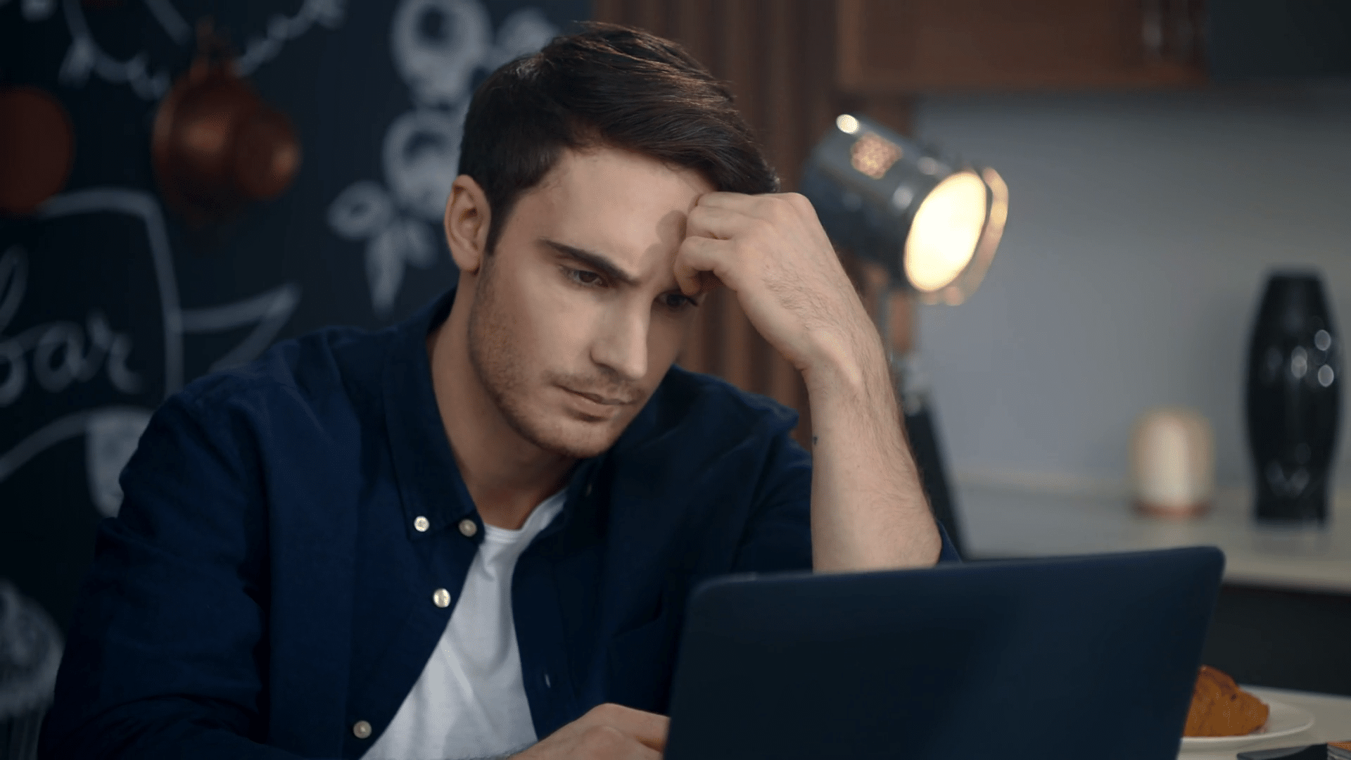 Propietario de negocio local frustrado frente al ordenador intentando estrategias de posicionamiento sin éxito